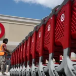 A Target store employee collects shopping carts to bring back into the store on Aug. 21, 2019, in Pembroke Pines, Fla. Workers are more likely to stay in their roles over the next six months, Eagle Hill Consulting’s most recent analysis of employee sentiment has found.