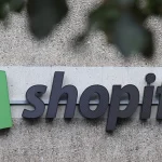 The corporate logo of e-commerce company Shopify hangs at the building that contains the Shopify offices on Aug. 8, 2022, in Berlin, Germany. Shopify is among the companies that have declared a definitive shift toward AI. Sean Gallup via Getty Images