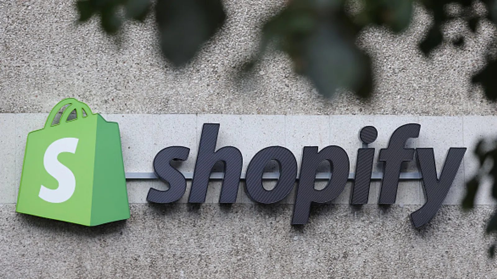 The corporate logo of e-commerce company Shopify hangs at the building that contains the Shopify offices on Aug. 8, 2022, in Berlin, Germany. Shopify is among the companies that have declared a definitive shift toward AI. Sean Gallup via Getty Images