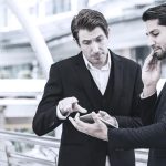 Two business men in discussion looking at tablet