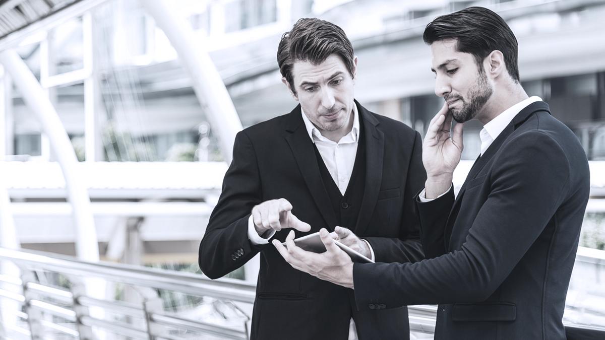 Two business men in discussion looking at tablet