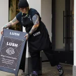 A Lush employee puts out a sign about the KultureCity pilot program. The latter organization, which supports people with sensory disabilities, partnered with Lush as apart of Autism Awareness Month.
